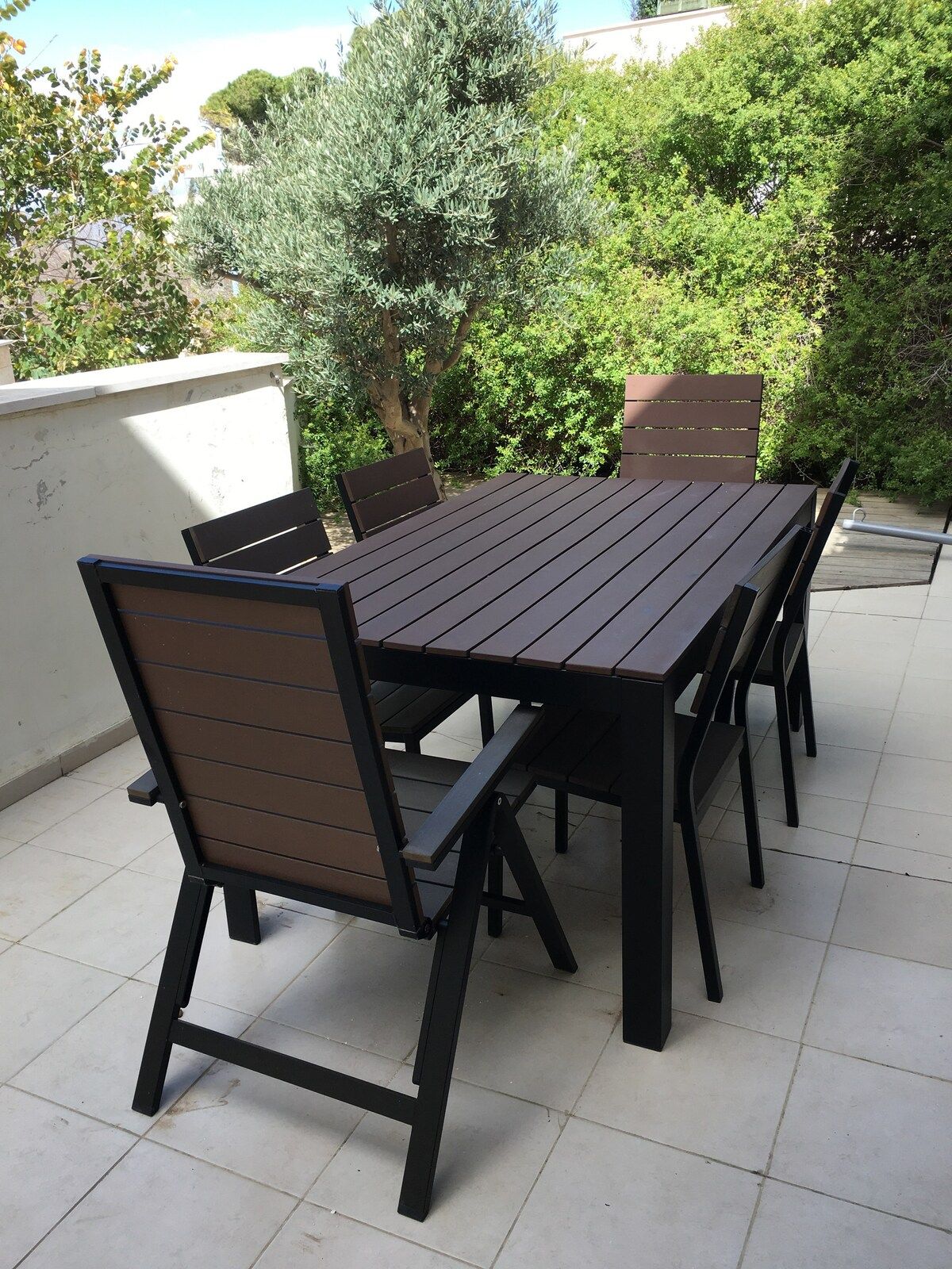 Shaded garden terrace with a dining table and chairs