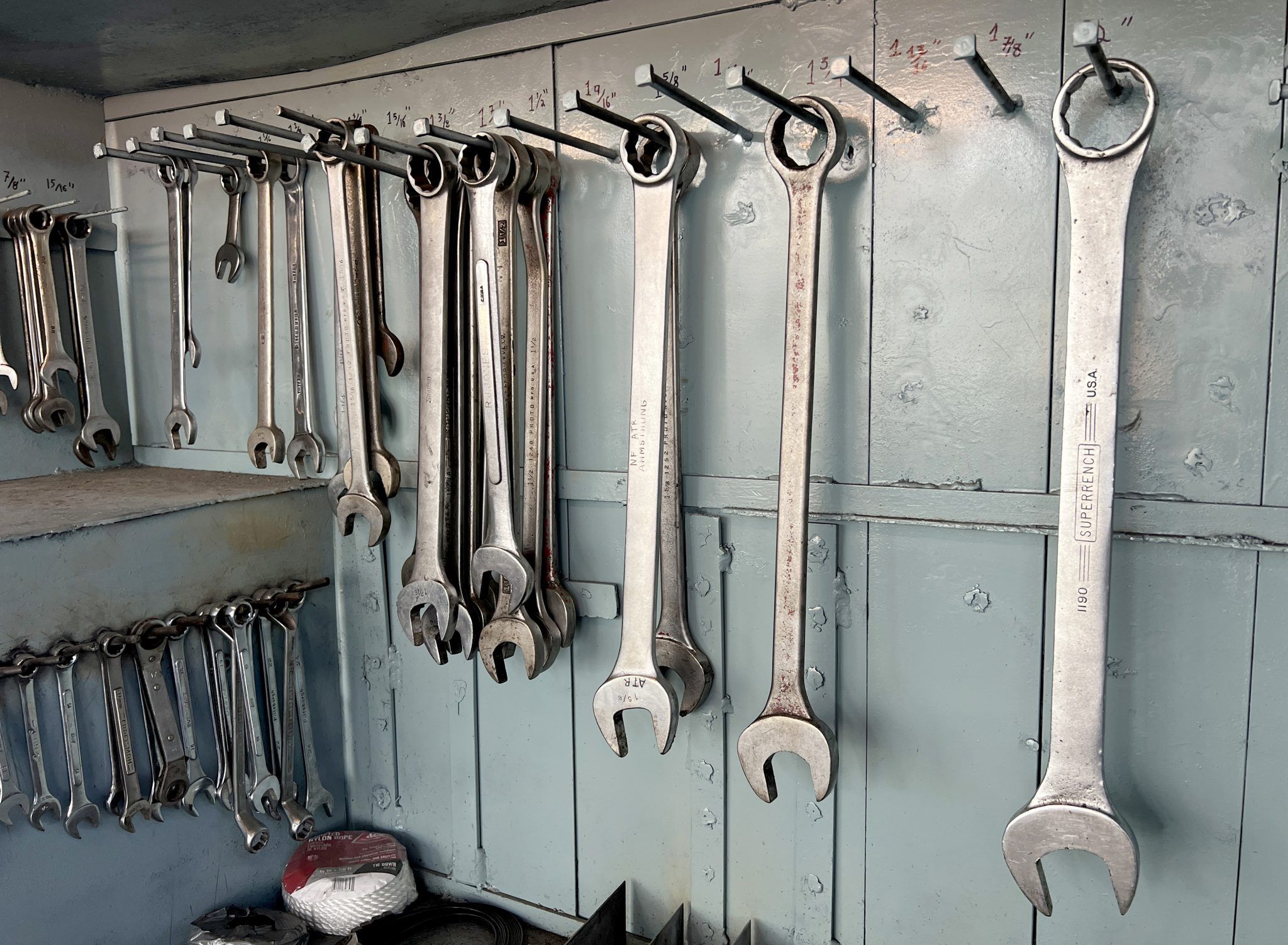 Wrenches hanging in an orderly row on a workshop wall